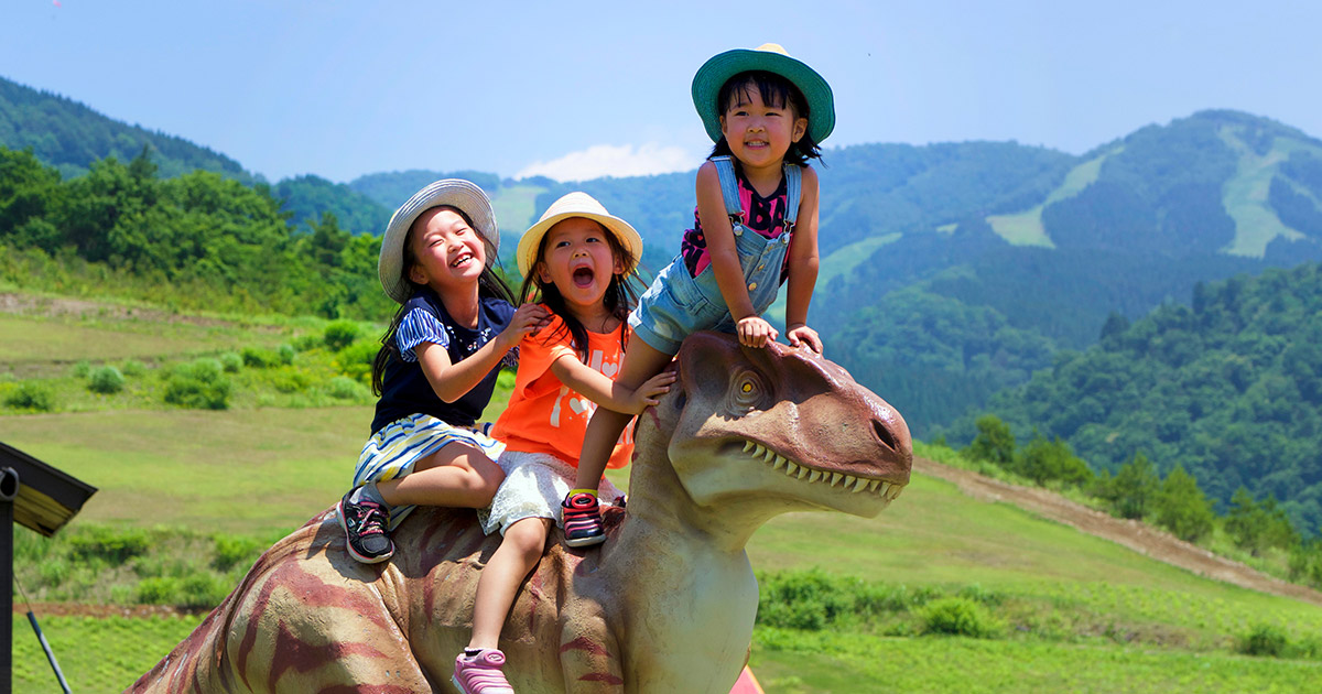 福井の日帰りグランピングBBQ（バーベキュー）子供が恐竜モニュメントに乗っている様子